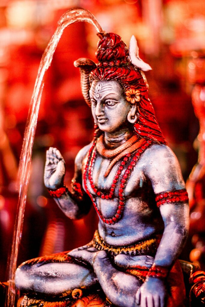 Close-up of a colorful Lord Shiva statue with water flow, capturing spiritual essence.